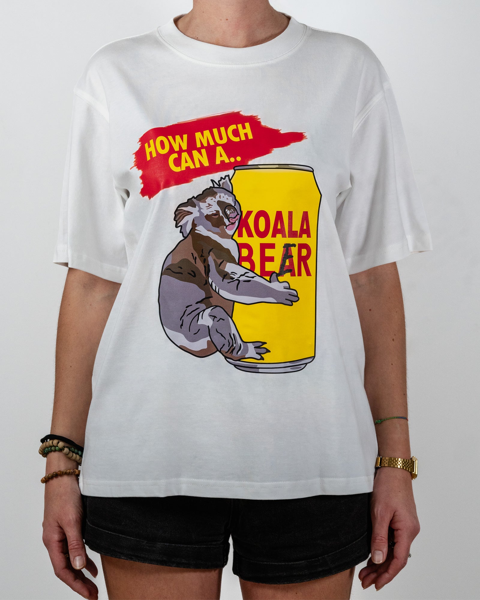 Person wearing a white t-shirt with a koala bear graphic and text standing against a plain background.