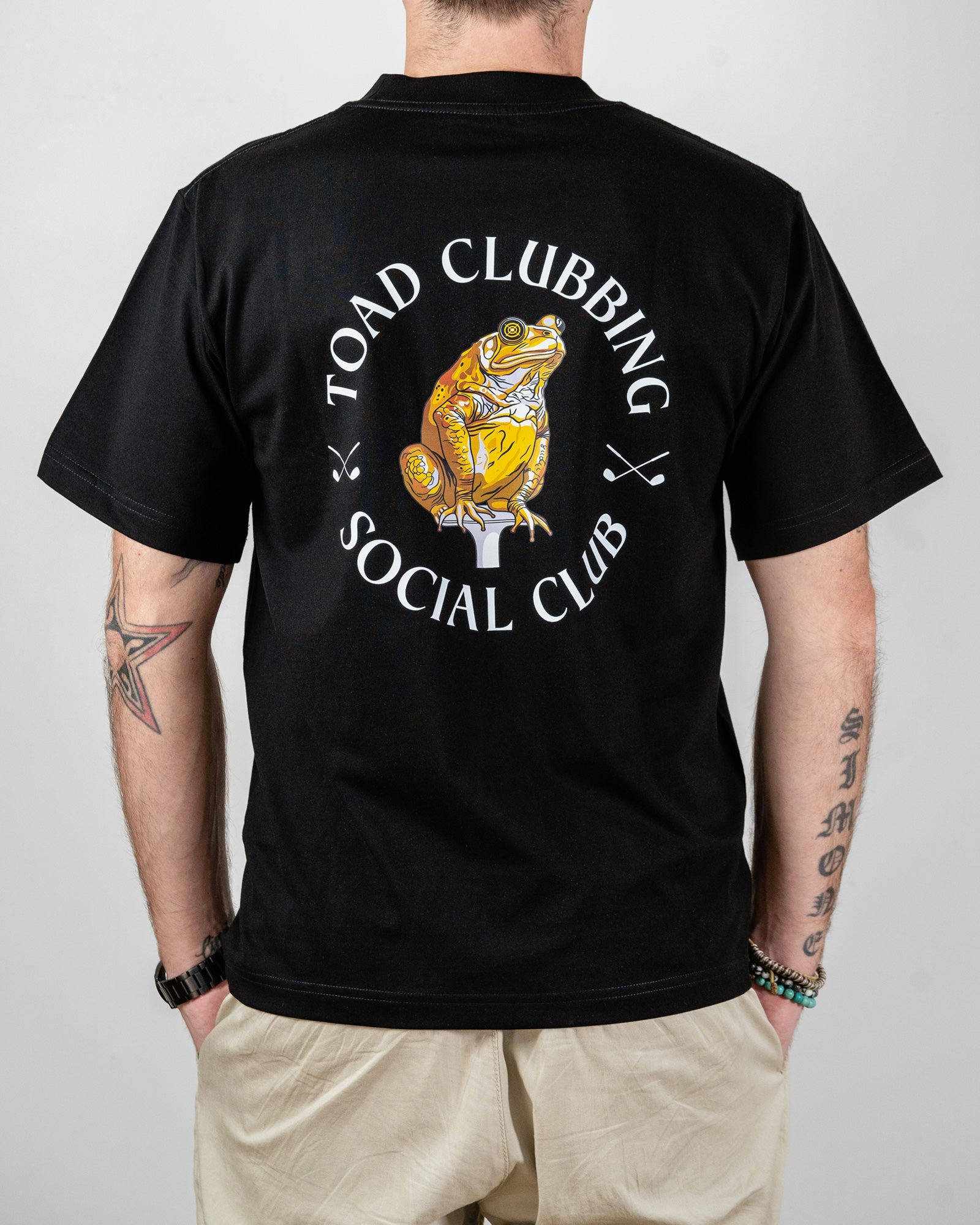 Black t-shirt with 'Toad Clubbing Social Club' design on the back, worn by a person.
