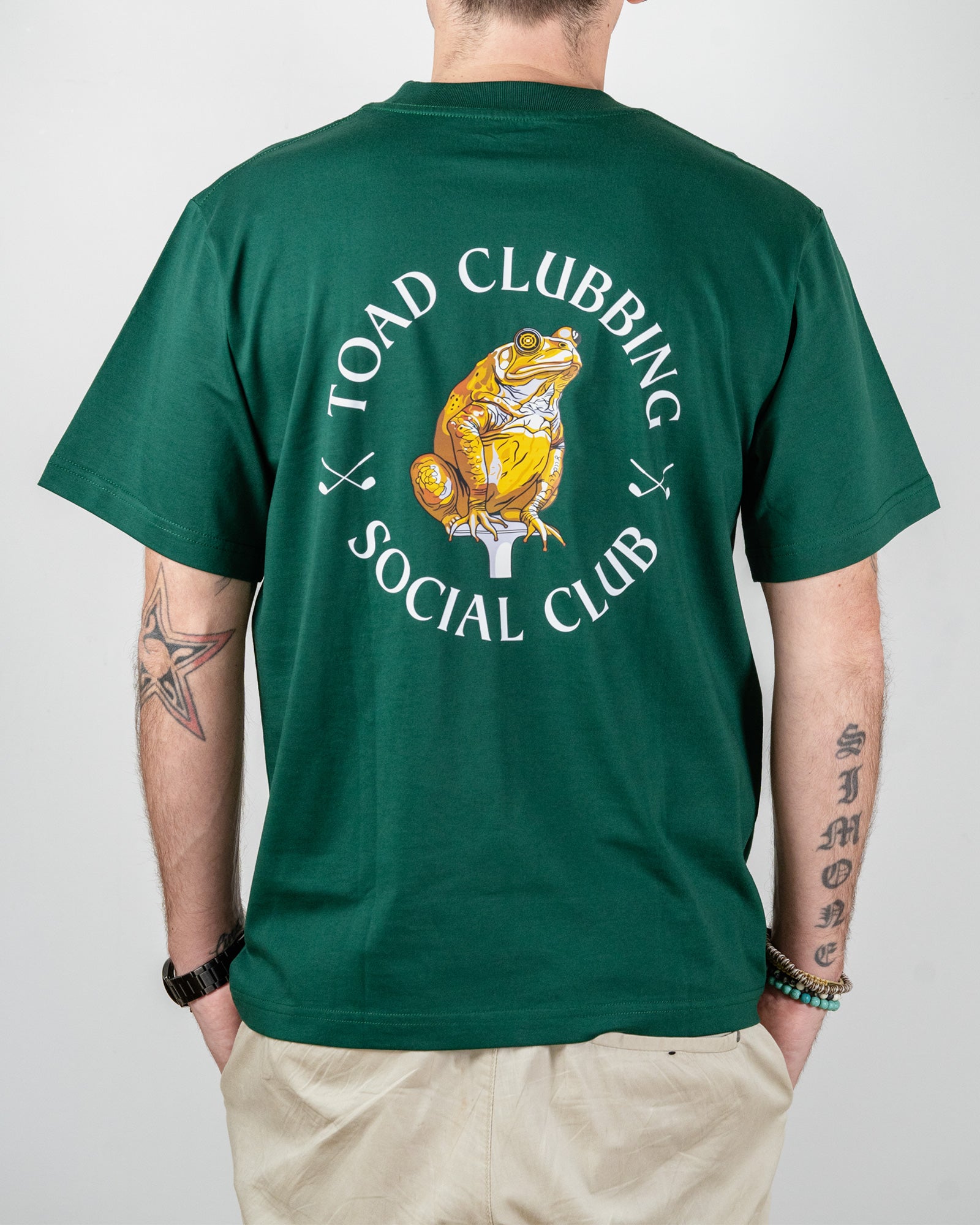Person wearing a green t-shirt with 'Toad Clubbing Social Club' design on the back.