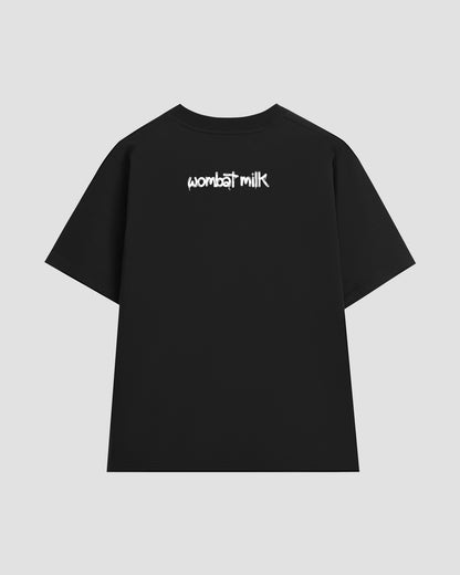 Black t-shirt with 'wombat milk' text on the back against a light grey background.