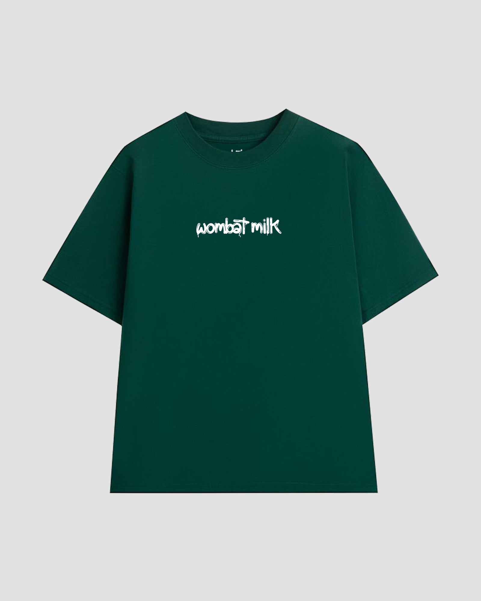 Green t-shirt with 'wombat milk' text against a light grey background.