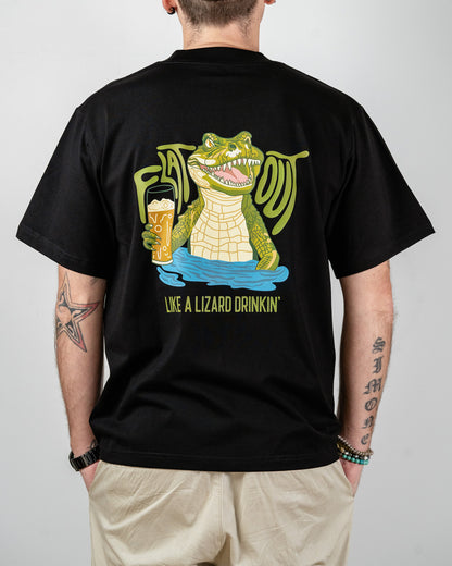 Person wearing a black t-shirt with a graphic of a crocodile drinking beer and text on the back that says 'Flat Out Like A Lizard Drinkin'.