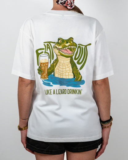 Person wearing a white t-shirt with a graphic of a crocodile drinking beer and text on the back that says 'Flat Out Like A Lizard Drinkin'.
