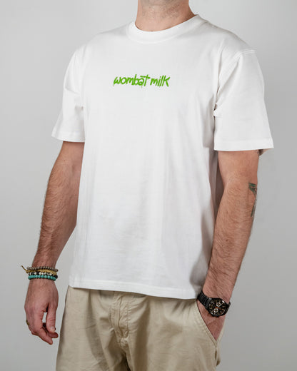 Person wearing a white t-shirt with 'wombat milk' text standing against a plain background.