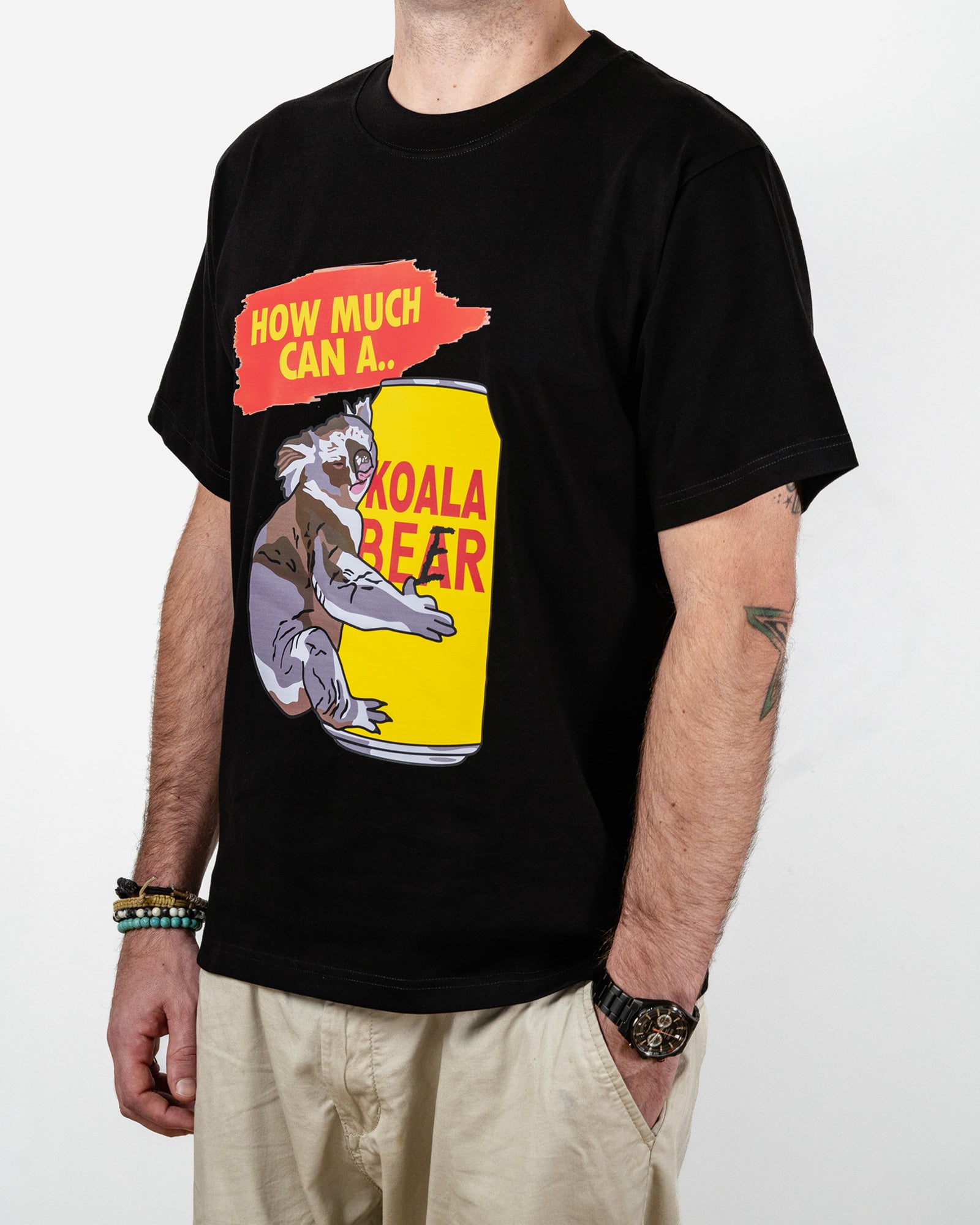 Person wearing a black t-shirt with a graphic of a koala bear on a can labeled 'Koala Beer' and text.