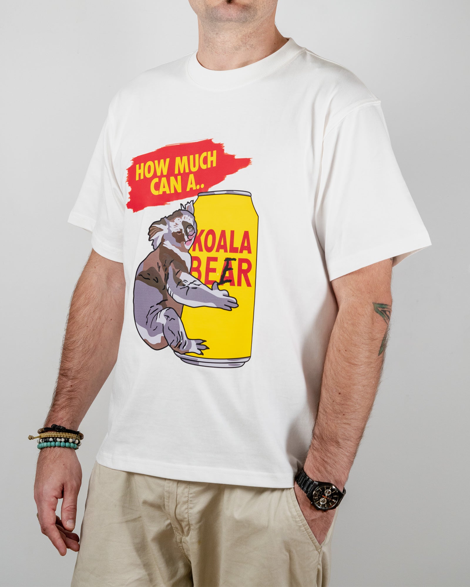 Person wearing a white t-shirt with a graphic of a koala bear on a beer can and text 'How much can a koala bear'.