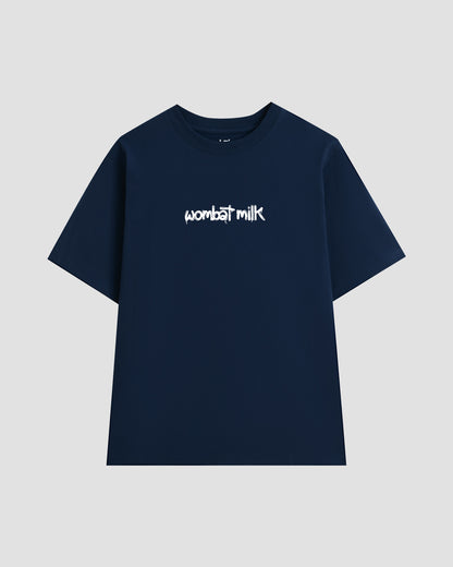 Navy t-shirt with 'wombat milk' text against a light grey background.